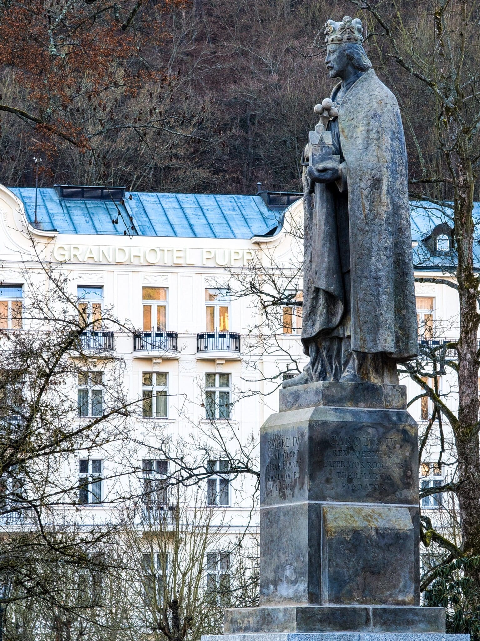 La statua di Carlo IV e sullo sfondo il Grandhotel Pupp La statua di Carlo IV e sullo sfondo il Grandhotel Pupp